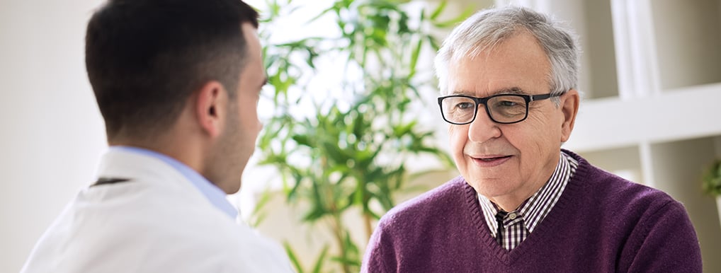 Image of a healthcare provider talking with an elderly man