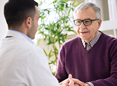 Image of a healthcare provider talking with an elderly man