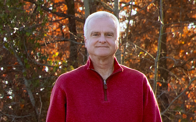 Image of a man outside with trees in the background